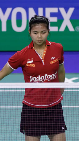 What is Greysia Polii's main discipline in badminton?