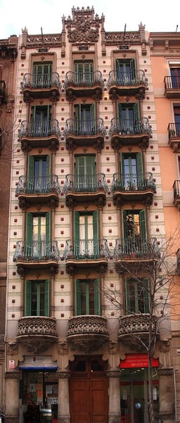 In which building did Domènech i Montaner first apply advanced solutions such as visible iron structure and ceramics?
