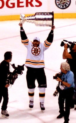 Who holds the record for most goals scored in a single season for the Boston Bruins?