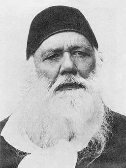 What type of reinterpretation of the Quran was Syed Ahmad Khan known for?