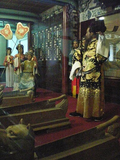 What distinctive hat is Bao Zheng portrayed with?