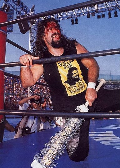 Under which wrestling promotion did Mick Foley first debut the persona known as Mankind?