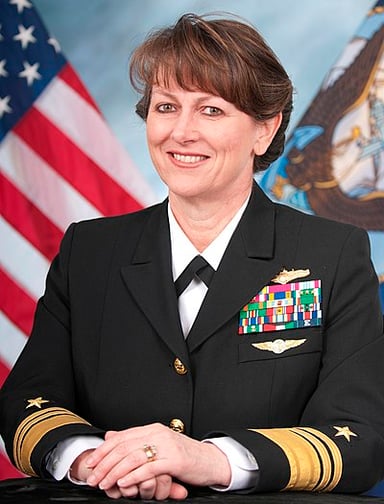 In which year did Jan E. Tighe retire from the United States Navy?