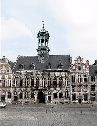 What is the name of the famous tower in Mons' town hall?