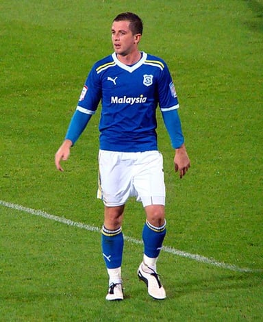 What is the color of the Cardiff City home shirt when Andrew Taylor played for them?