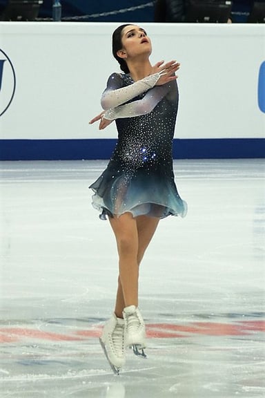 Evgenia was the first female skater to surpass which mark in the short program?