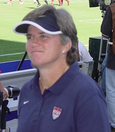 In which year did April Heinrichs retire from international soccer?
