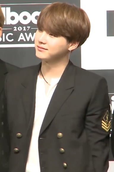 Under which entertainment company did Suga debut?