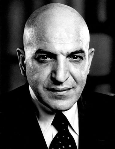 In what year did Telly Savalas achieve a UK number-one single as a singer?