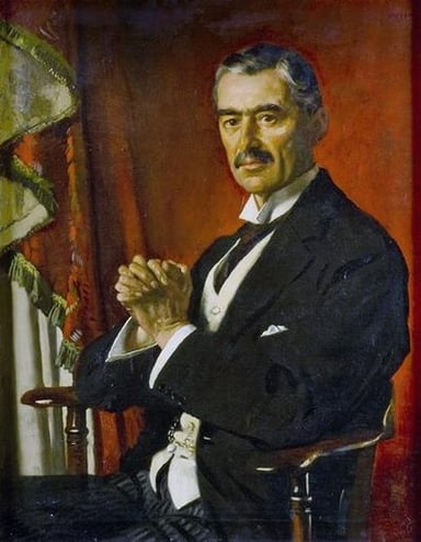 Which country did Neville Chamberlain pledge to defend, leading to the UK's entry into World War II?