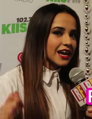 What genre does Becky G predominantly sing in?