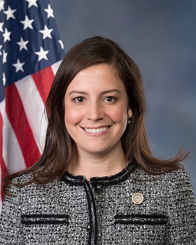 Elise Stefanik's district includes some suburbs of which city?
