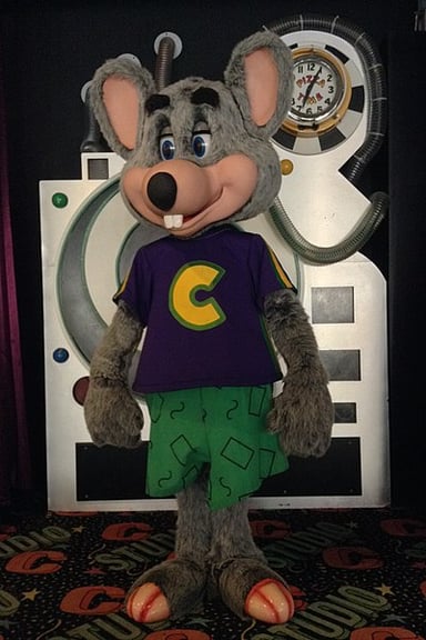 What was the parent company of Chuck E. Cheese and ShowBiz Pizza Place called after their merger?