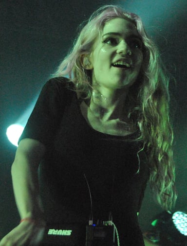 Which record label did Grimes sign with after releasing her first two albums?