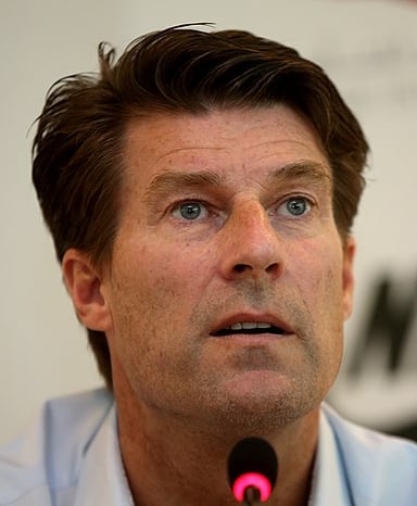 Which team did Laudrup coach to their first English trophy?