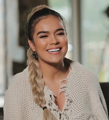 To which music label did Karol G sign in 2014? 
