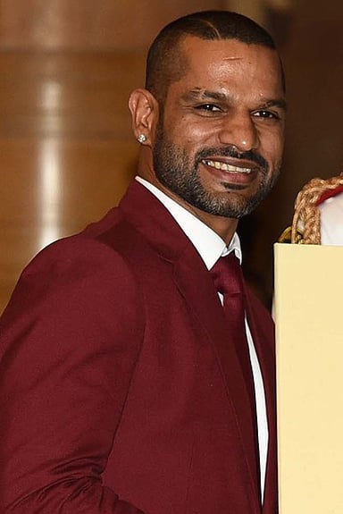 In which domestic team does Dhawan play first-class cricket?