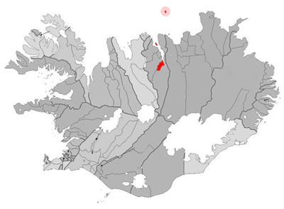 What geographical factor contributes to Akureyri's relatively mild climate?