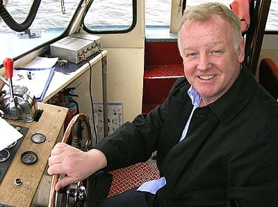 Does Les Dennis have a background in theater?