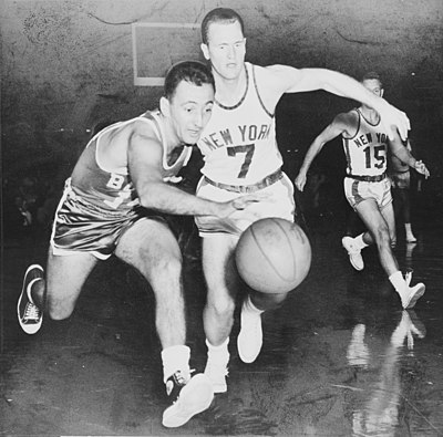 Which high school varsity squad did Bob Cousy make as a junior?