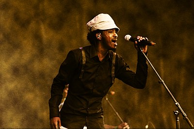 What topic does K'naan frequent in his lyrics?