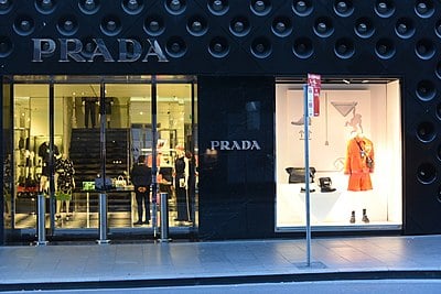 Which company does Prada license its name to for eyewear?