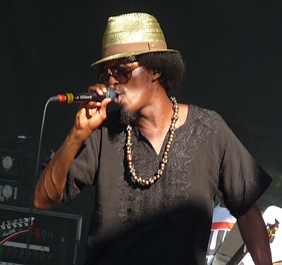 What type of music does K'naan specialize in?