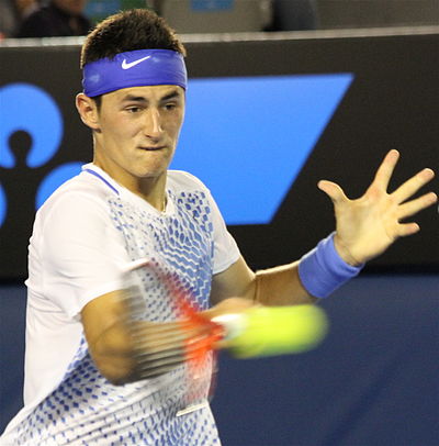 Which famous tennis player did Bernard Tomic defeat to win his first junior grand slam?