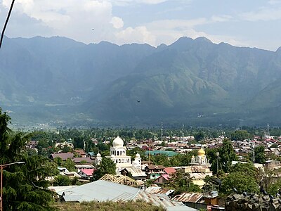 What is the name of the hill in Srinagar that houses an ancient temple dedicated to Lord Shiva?