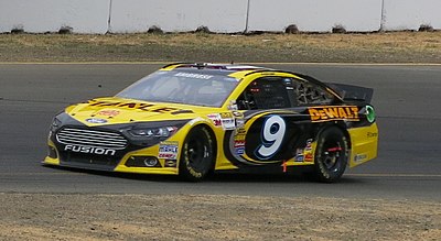 In what year did Marcos Ambrose move to the United States for pursuing NASCAR racing?