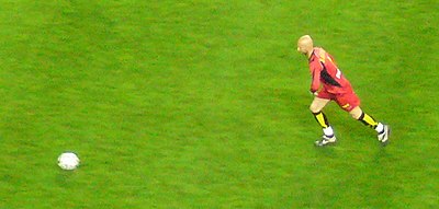 Barthez was known for playing with what distinctive physical trait?