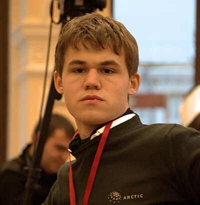 How many times has Carlsen held all three major chess titles simultaneously?