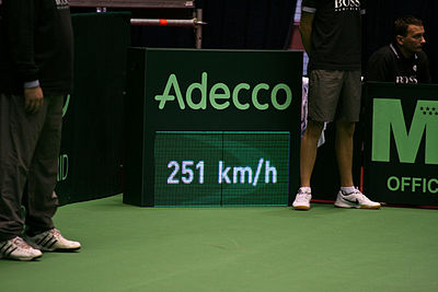 How is Karlović's serve trajectory described due to his height?