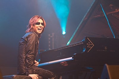 What genre is Yoshiki's band X Japan associated with?