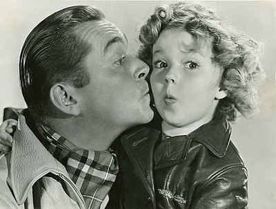 What type of merchandise featuring Shirley Temple's image was popular during her childhood acting career?