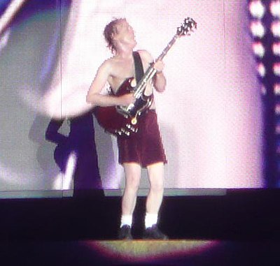 What is Angus Young known for wearing on stage?