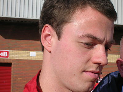 Which team did Jonny Evans play for on a loan basis before debuting for Manchester United first team?