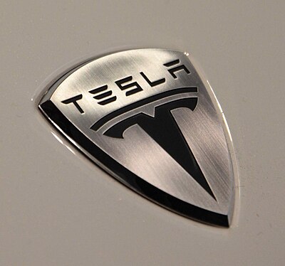 In what ticker symbol does Tesla,  trade?