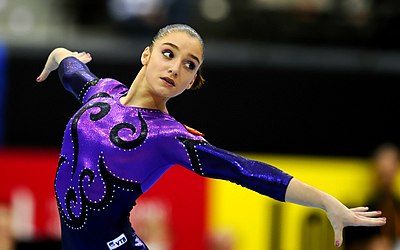 Who does Mustafina share the record for most medals won by a Russian gymnast?