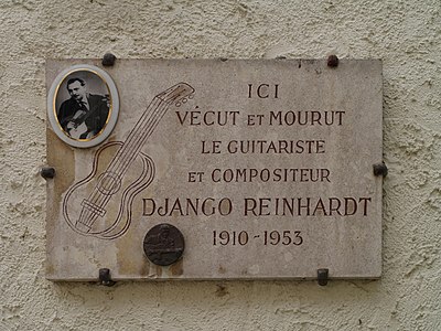 Is Django Reinhardt more associated with acoustic or electric guitar?